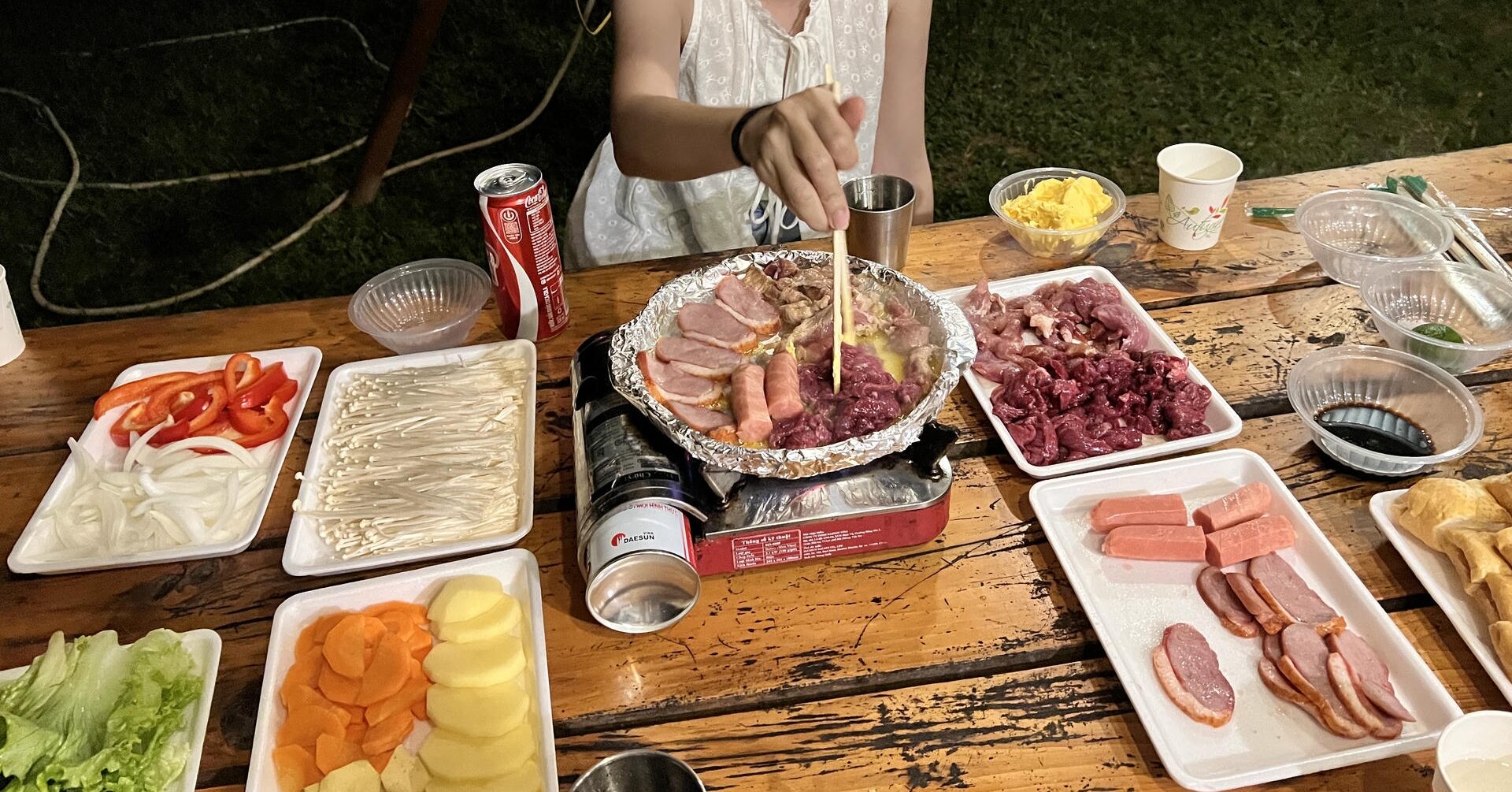 Barbecue dinner spread with grilled meat and vegetables at Angel Eye Mountain campsite.