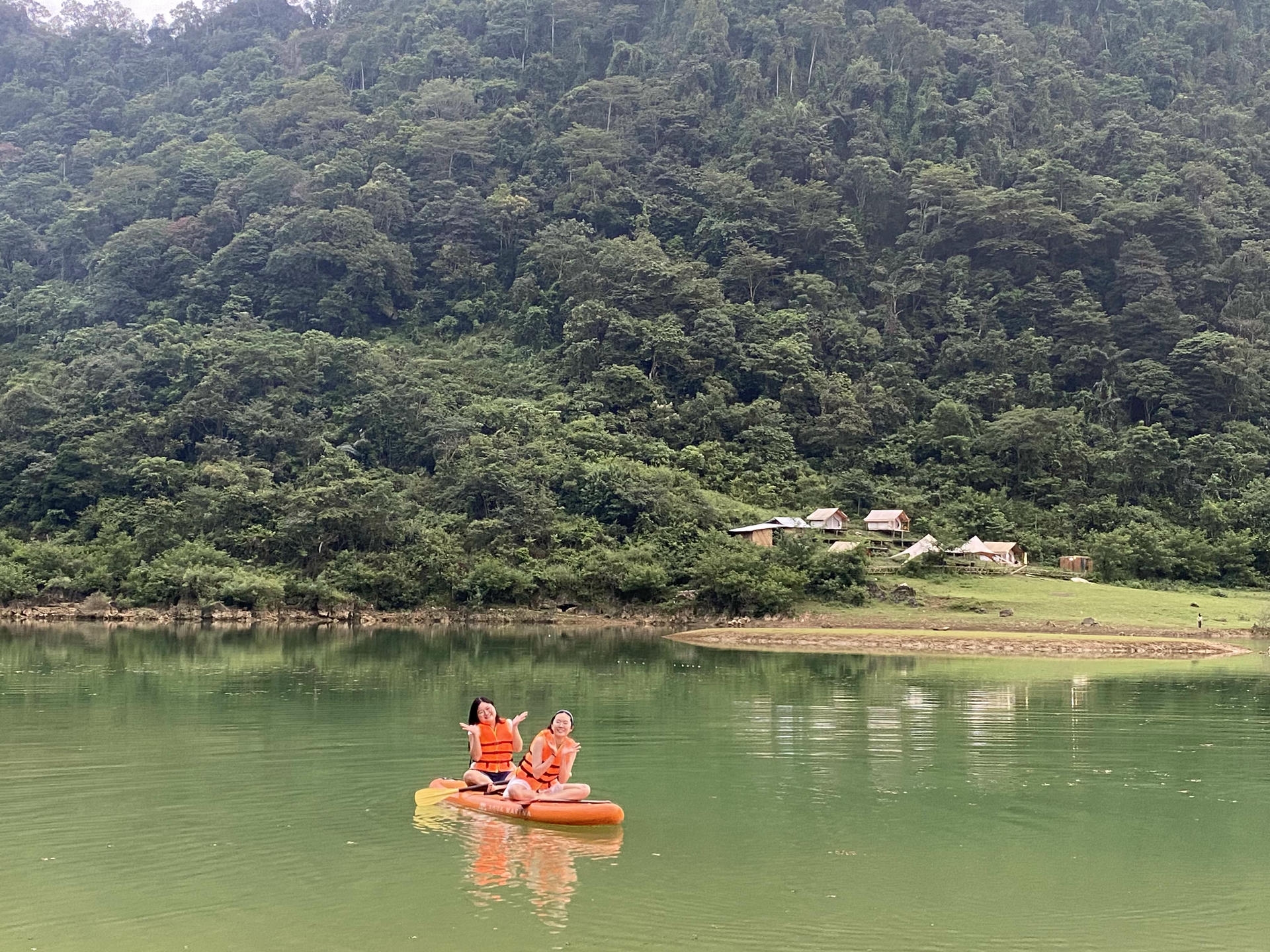 Traveler sitting on a SUP board on the flooded valley of Angel Eye Mountain in the rainy season.