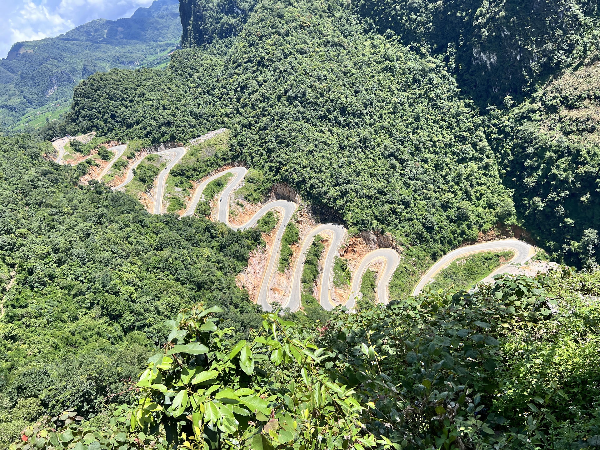 View of Khau Cốc Chạ Pass from the mountain viewpoint on the Cao Bang Loop with winding road below