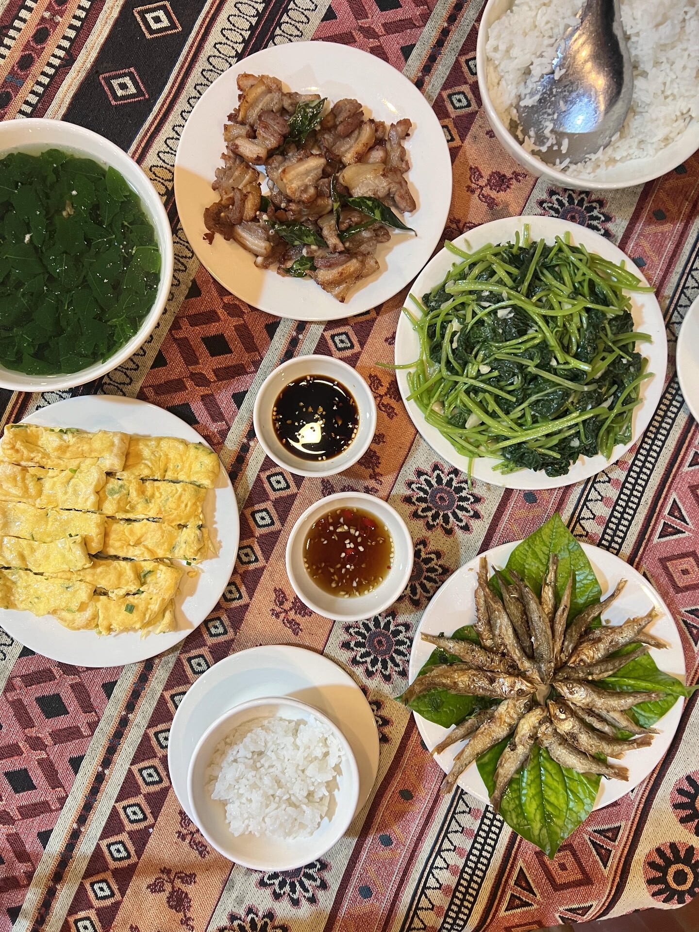 Traditional Tày family-style meal in Khuổi Ky Stone Village with fried stream fish, stir-fried greens, omelet, and pork belly