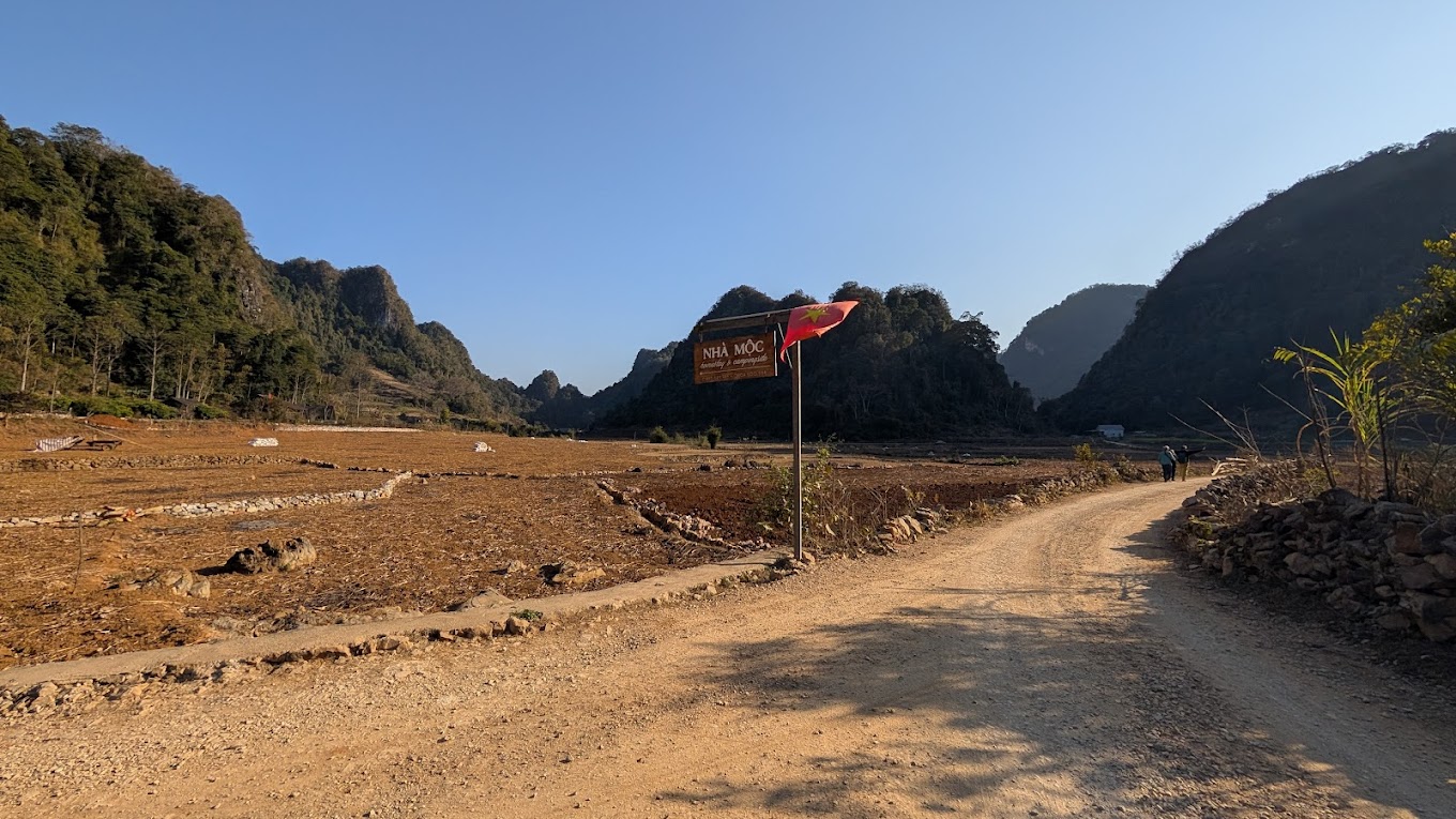 Wooden sign of Nhà Mộc Homestay, the landmark to reach Angel Eye Mountain campsite.